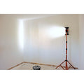 Edma cordless LED inspection light on its telescopic stand, lighting a newly plastered room